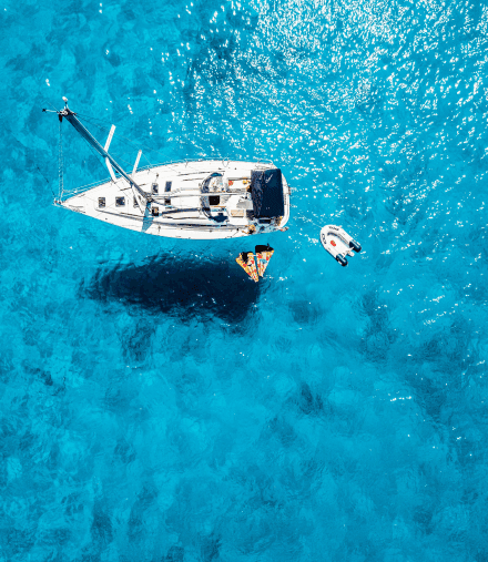 Foto desde arriba de un bote sobre el mar azul claro